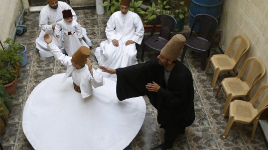 Sufi Dervish dancer Mahmoud al-Kharrat (R), 34, guides other members of his family as they dance at a courtyard in their house